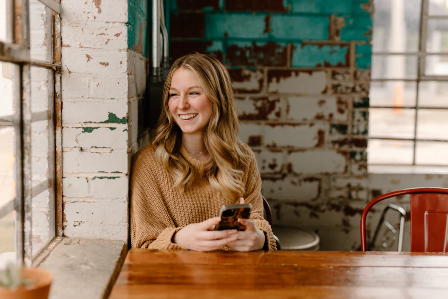Cliente sorrindo com o celular em um café