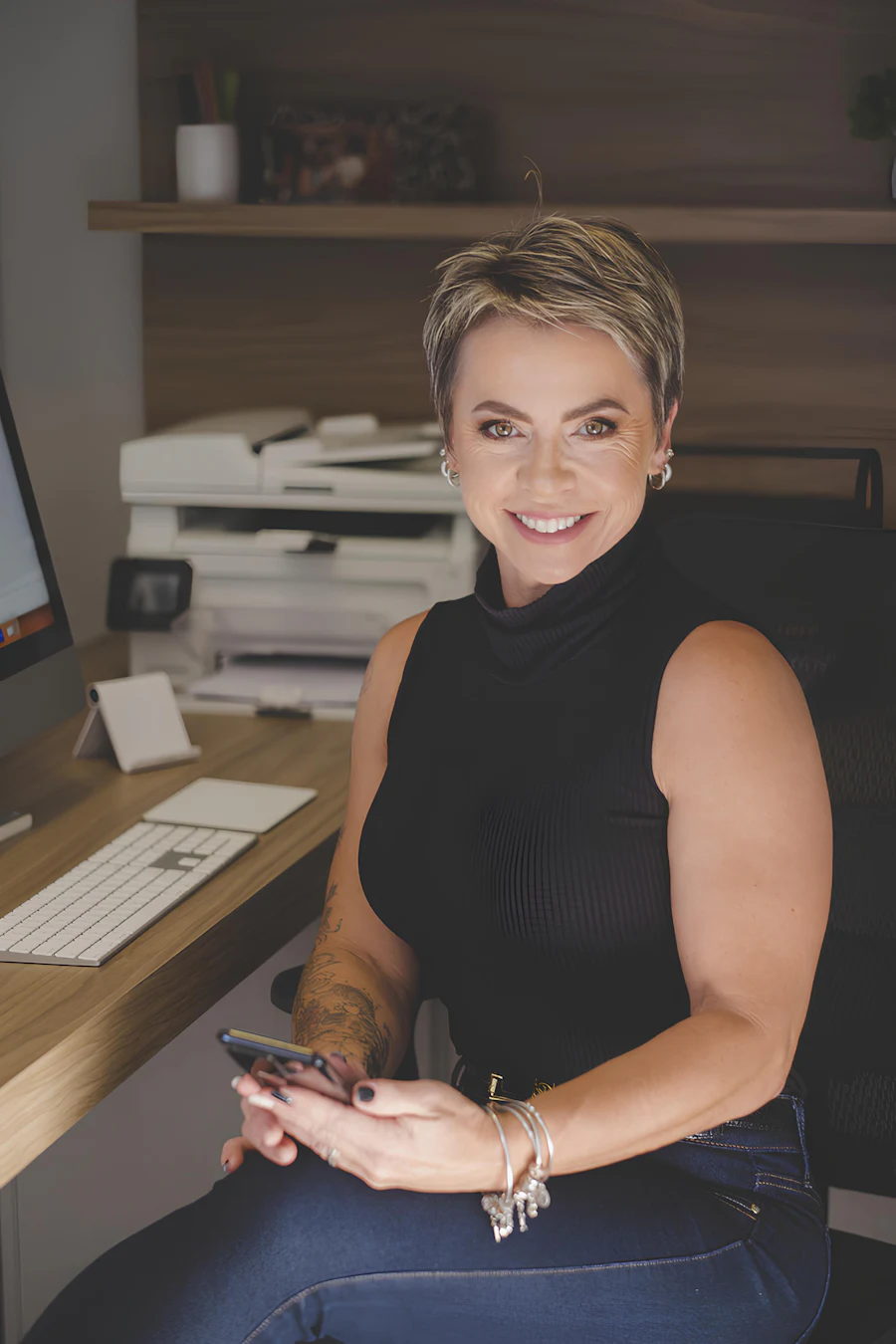 Profissional sorrindo enquanto usa o celular no escritório